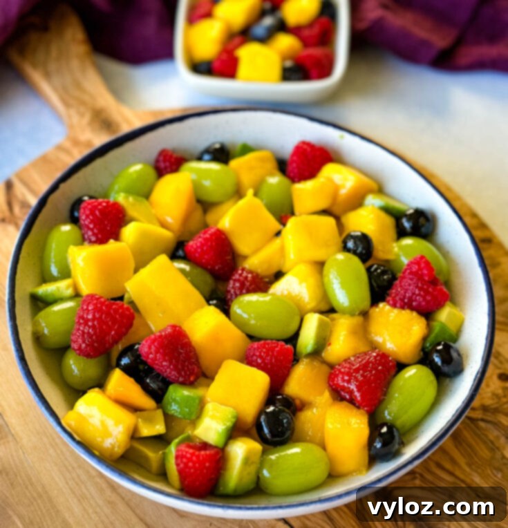 Refreshing Mango Fruit Salad with berries, grapes, avocado, and honey lime dressing
