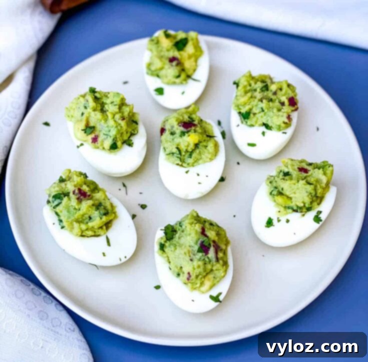 Easy Avocado Deviled Eggs stuffed with bacon, cilantro, and onion, without mayo