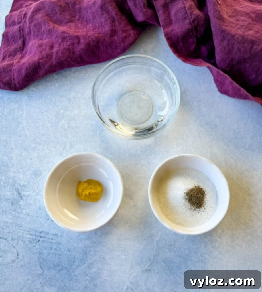 Separate white bowls holding key vinegar coleslaw dressing ingredients: vinegar, mustard, sweetener, salt, and pepper