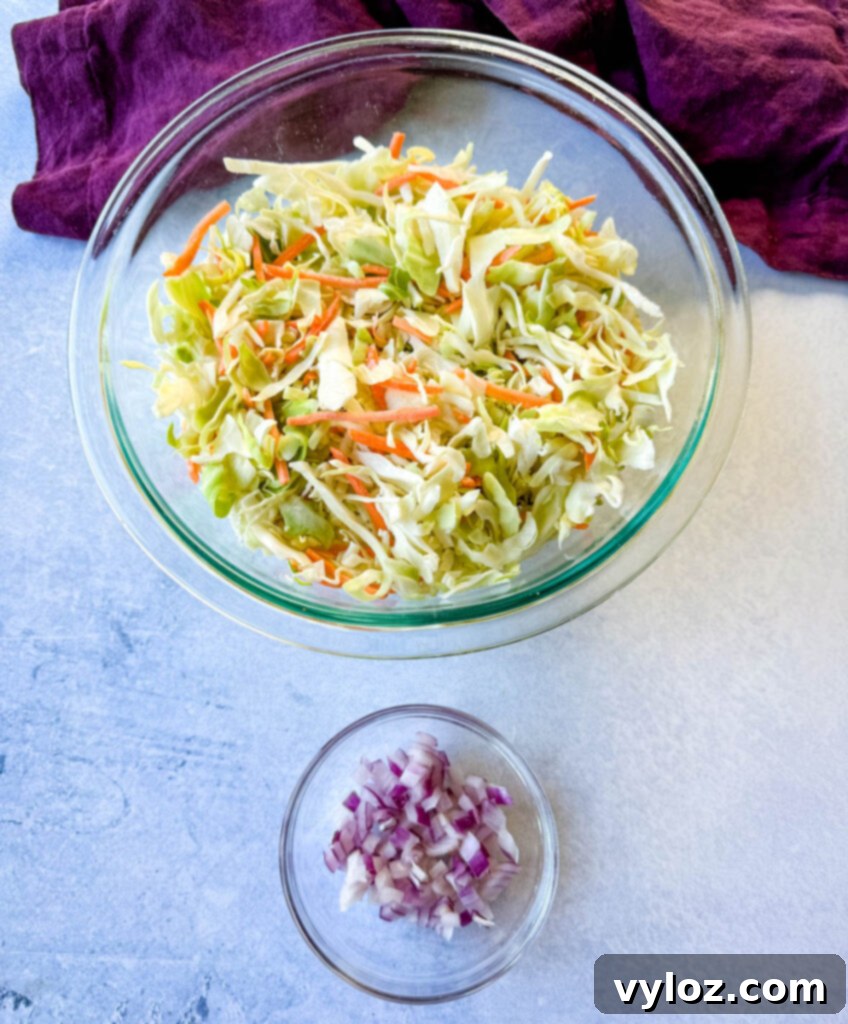 Shredded cabbage coleslaw mix and finely diced onions displayed in separate clear glass bowls, ready for mixing