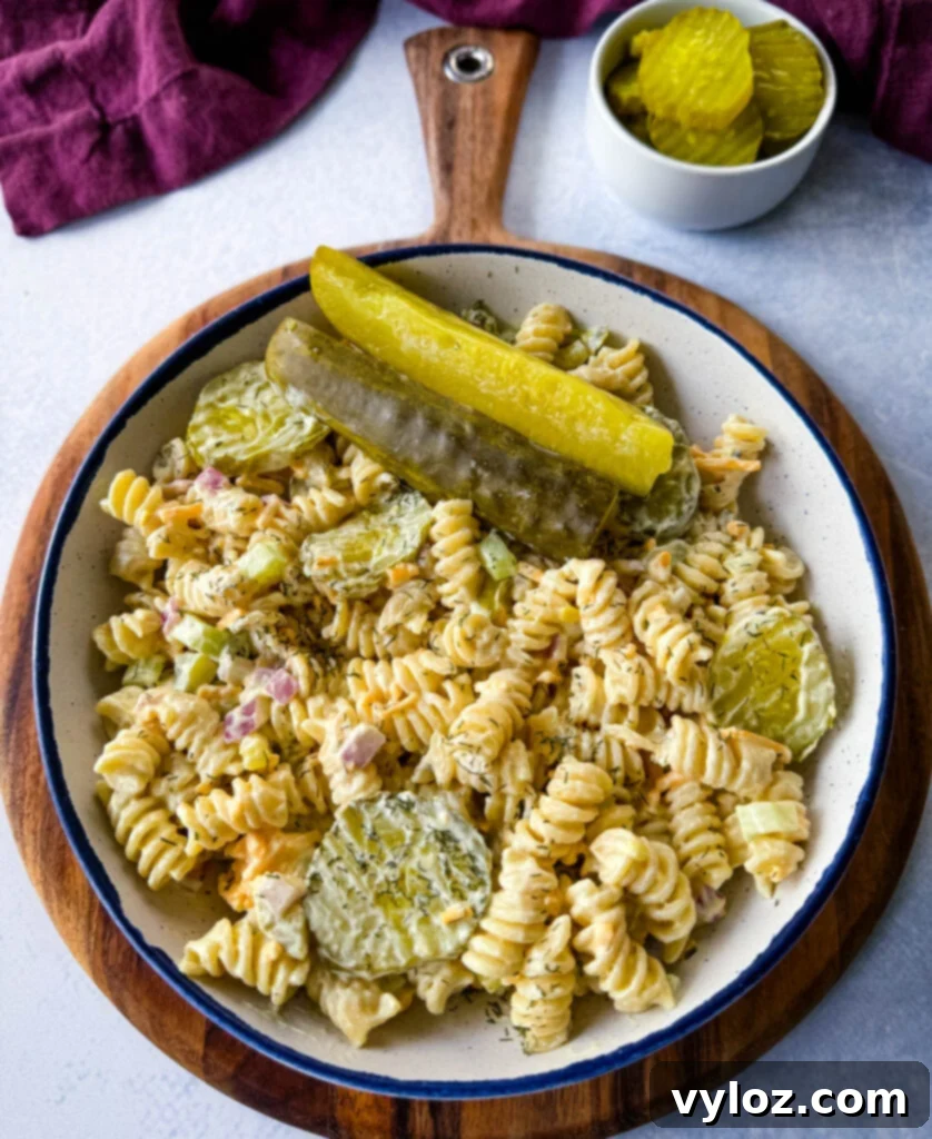 Zingy Dill Pasta Salad 2 A vibrant bowl of dill pickle pasta salad, garnished with fresh dill and pickle spears, ready to be served at a gathering.