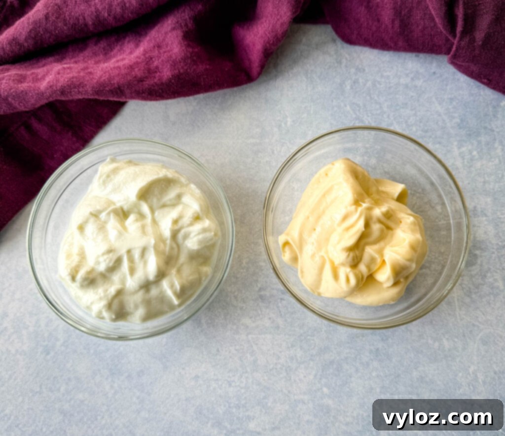 Zingy Dill Pasta Salad 4 Individual glass bowls holding creamy mayonnaise and plain Greek yogurt, key ingredients for the rich and tangy dressing.