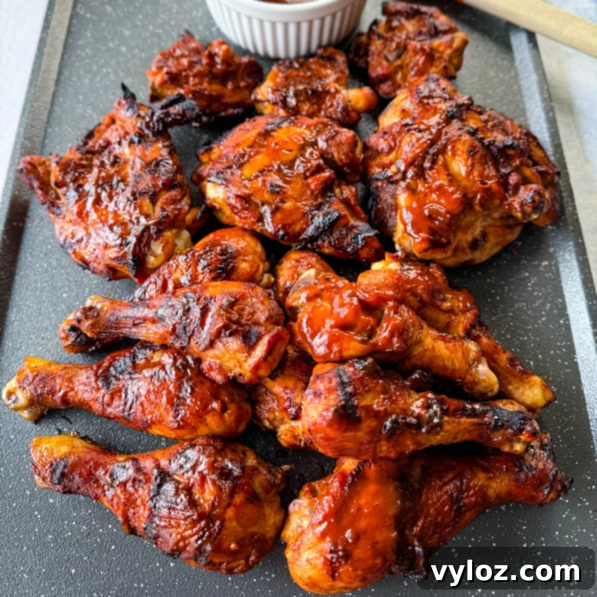 grilled bbq chicken thighs and drumsticks on a sheet pan with bbq sauce