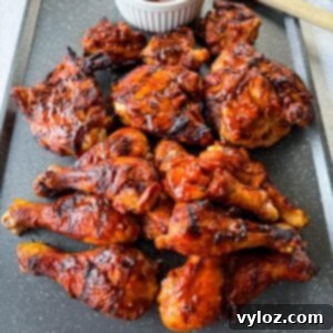 grilled bbq chicken thighs and drumsticks on a sheet pan with bbq sauce