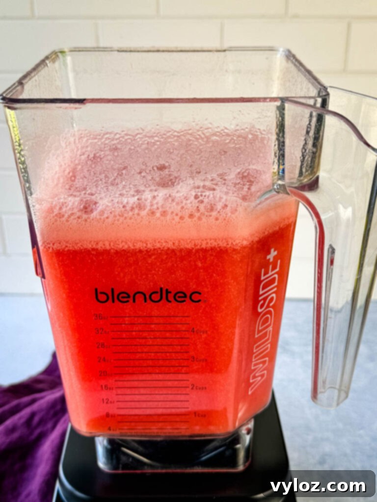 More watermelon blending in a blender, illustrating the ease of preparation.