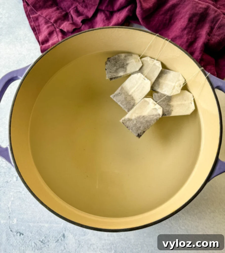 Water and tea bags simmering in a Dutch oven, starting the tea brewing process