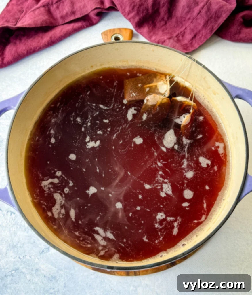 Hot, steeped tea and used tea bags in a Dutch oven, ready for removal