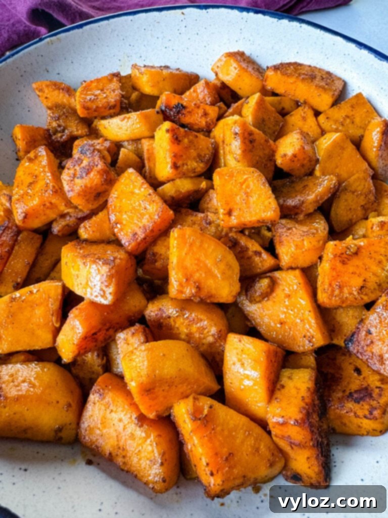 A serving of golden-brown fried sweet potatoes in a white bowl, freshly cooked and steaming.
