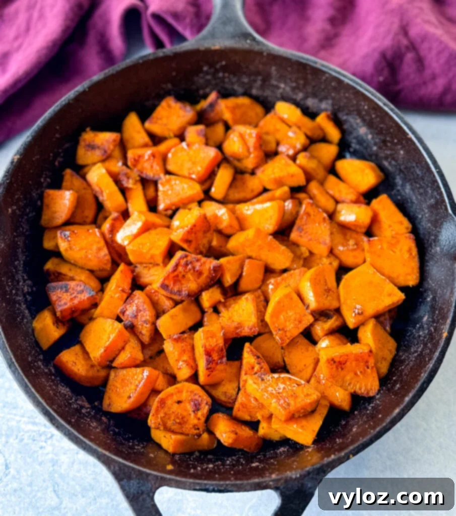 Fried sweet potatoes in a cast iron skillet after cooking, showcasing their golden-brown, caramelized texture.