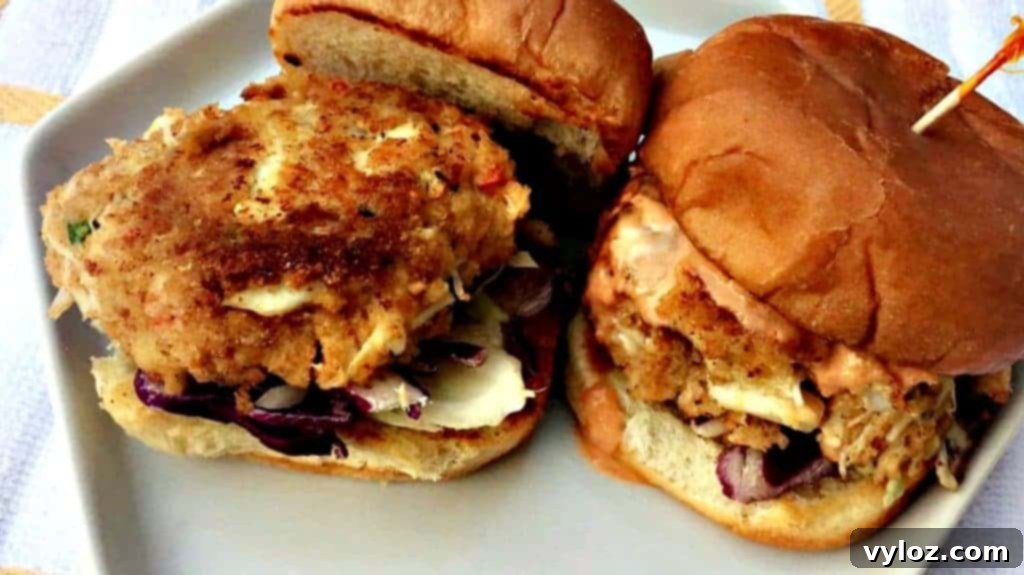 Crab Cake Sliders Crab Cake on a slider bun with Chipotle Mayo on a white plate