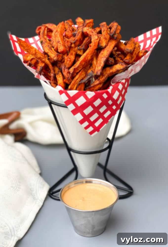 air fryer sweet potato fries in a white basket with a red and white napkin