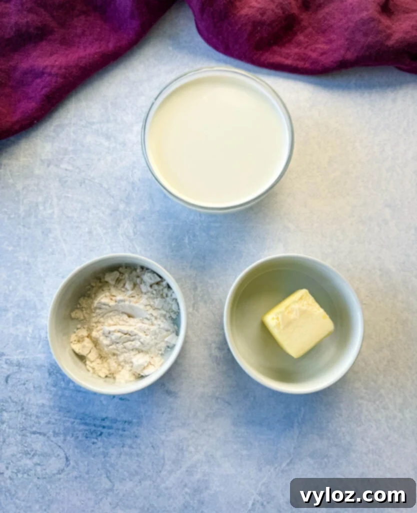Individual white bowls containing half and half (or milk), all-purpose flour, and unsalted butter, key ingredients for country gravy.