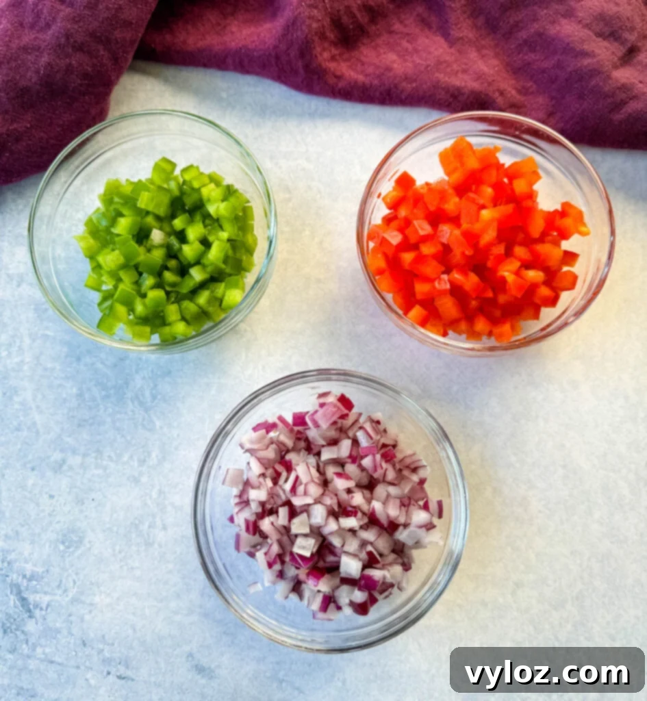 diced green peppers, diced red peppers, and diced onions in separate glass bowls