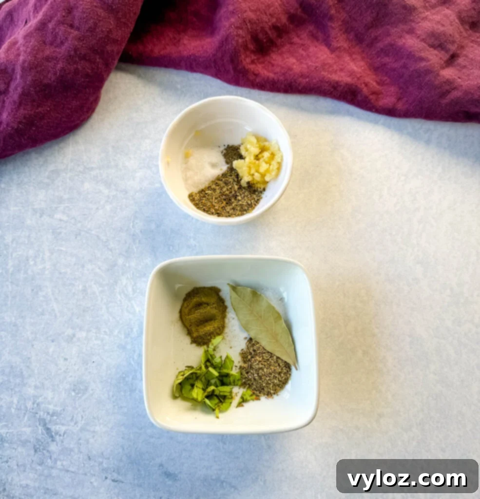 garlic, Italian seasoning, basil, bay leaf, salt and pepper in separate white bowls