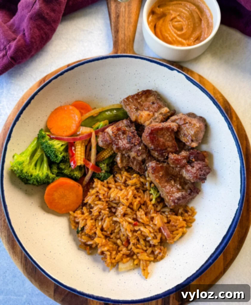 hibachi steak, vegetables, and fried rice in a white bowl