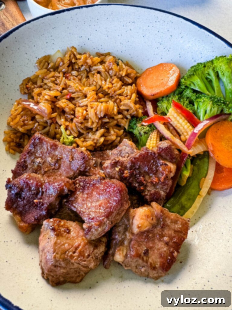 hibachi steak, vegetables, and fried rice in a white bowl