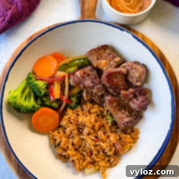 hibachi steak, vegetables, and fried rice in a white bowl
