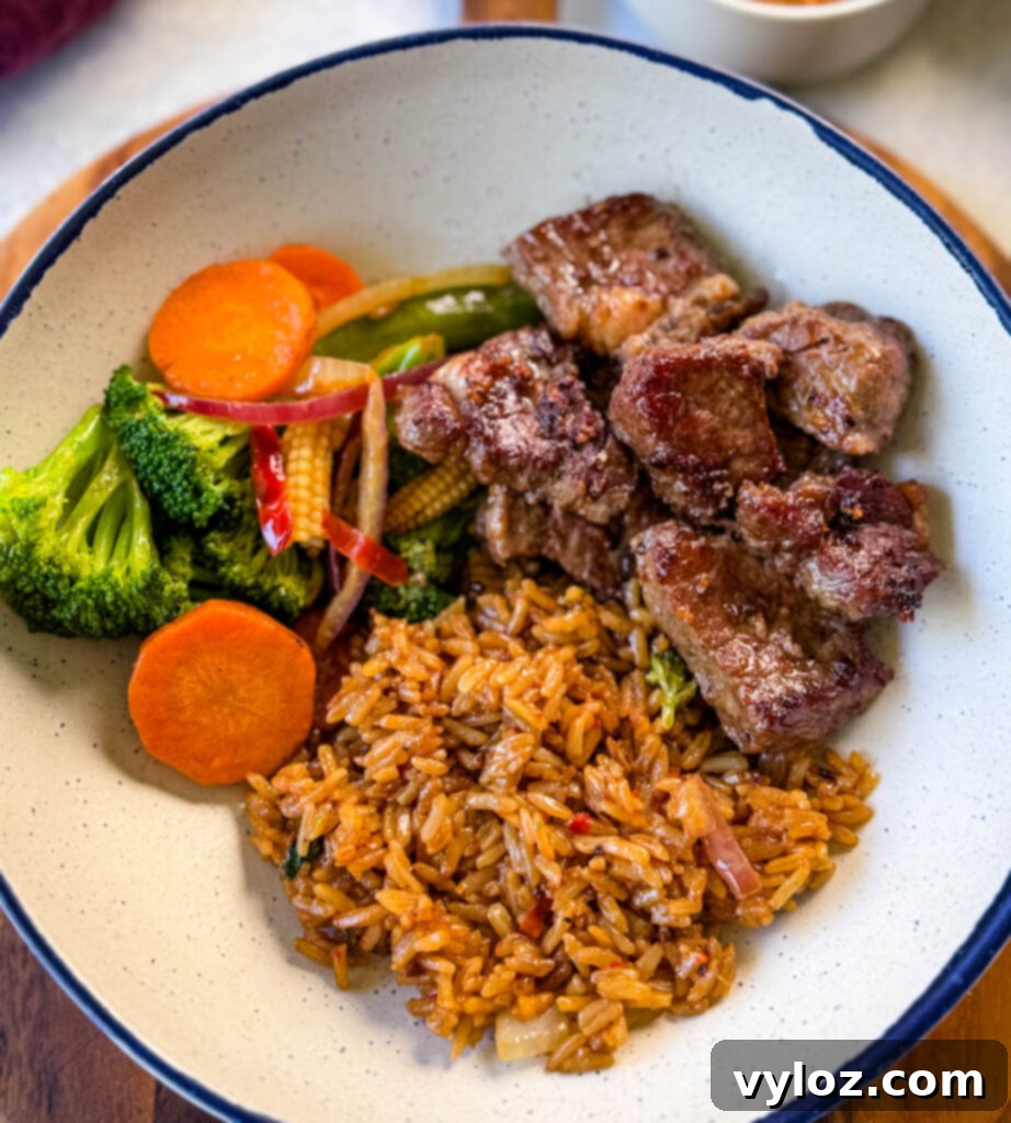 hibachi steak, vegetables, and fried rice in a white bowl