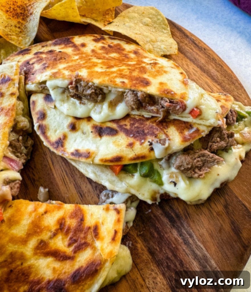 Philadelphia cheesesteak on a flat surface with chips