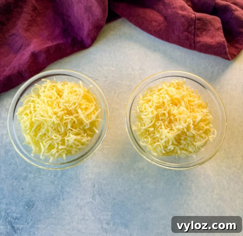 grated provolone and mozzarella cheese in separate glass bowls
