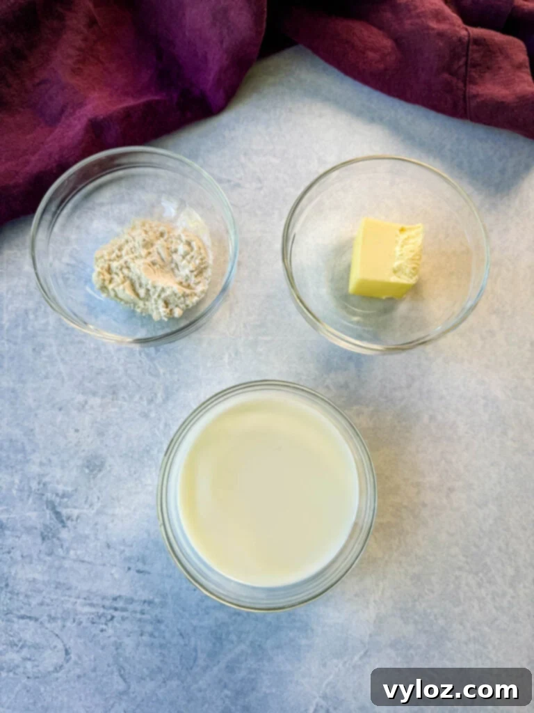 Separate glass bowls containing flour, butter, and milk, ready for making homemade Cheez Whiz