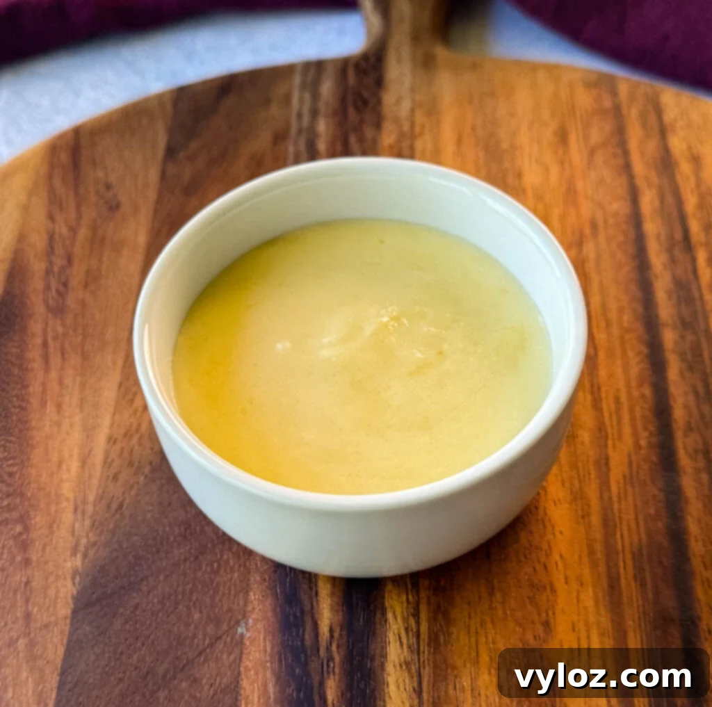 A pristine white bowl filled with creamy homemade Cheez Whiz, ready for dipping