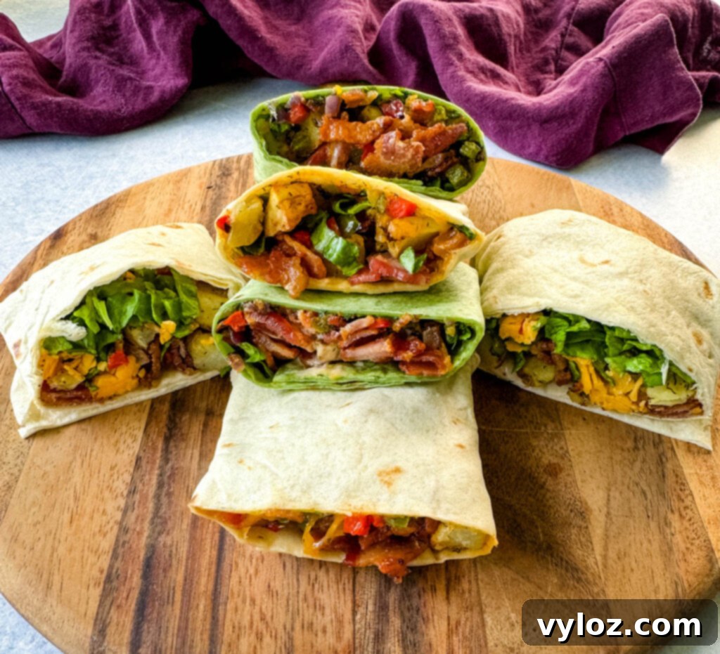 breakfast burritos with bacon, potatoes, bell peppers and cheese on a flat surface