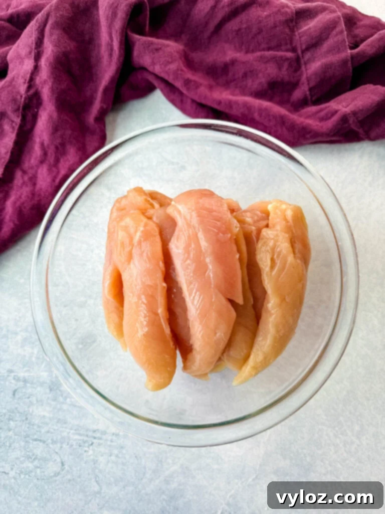 Sweet Heat Honey Chicken Bowls 5 Raw boneless, skinless chicken tenderloins in a glass bowl, ready for seasoning.