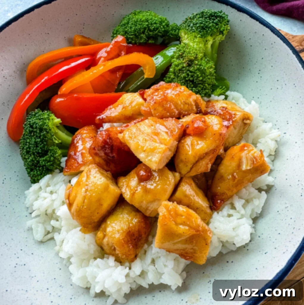 Sweet Heat Honey Chicken Bowls 9 A hot honey chicken and rice bowl with broccoli and bell peppers, perfectly cooked and ready to eat.