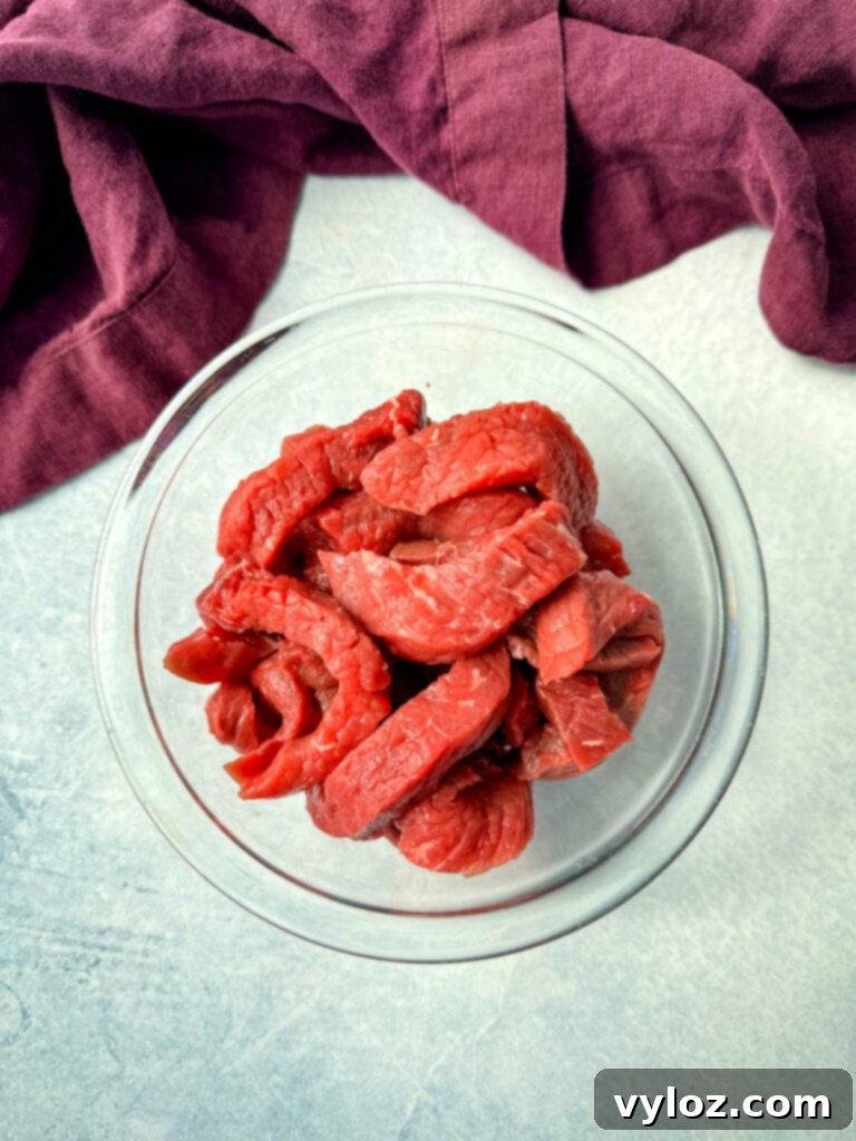 Ramen Noodle Beef and Broccoli Stir Fry 4 raw sliced flank steak i a glass bowl