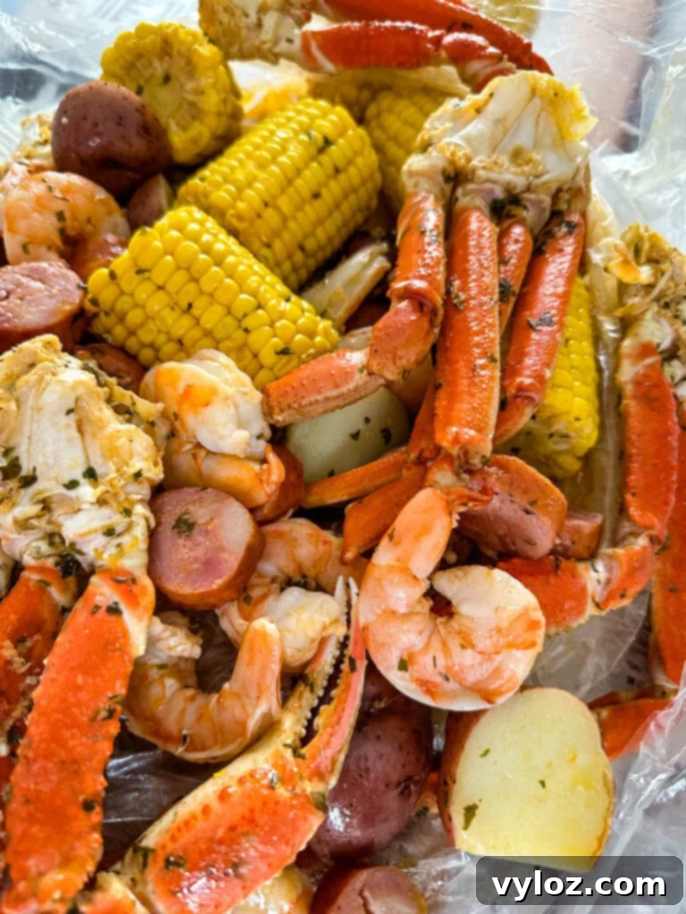 Garlic Butter Seafood Boil Bag 12 A vibrant seafood boil in a bag, showcasing the variety of ingredients including snow crab clusters, shrimp, potatoes, corn, and sausage.