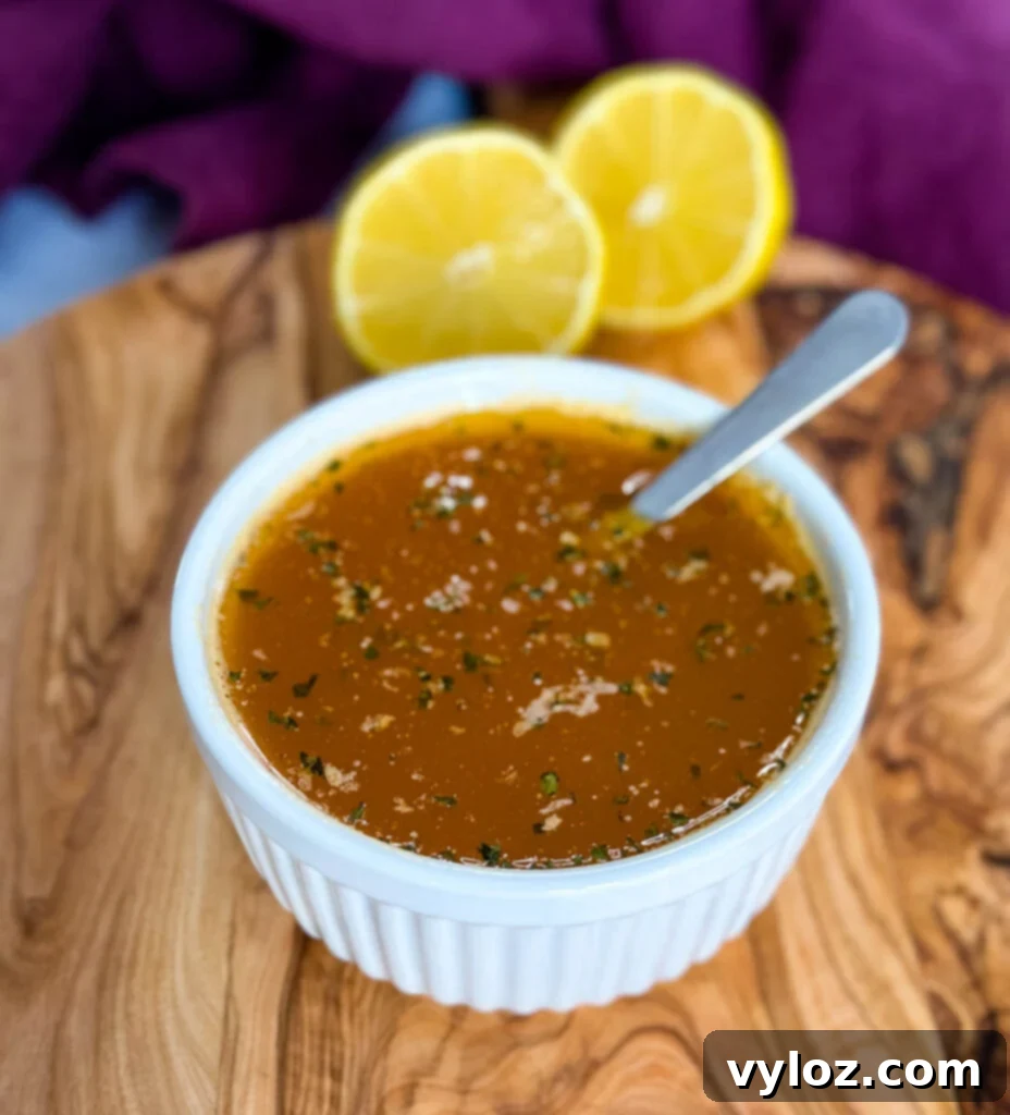 seafood boil garlic butter sauce in a white bowl with a spoon