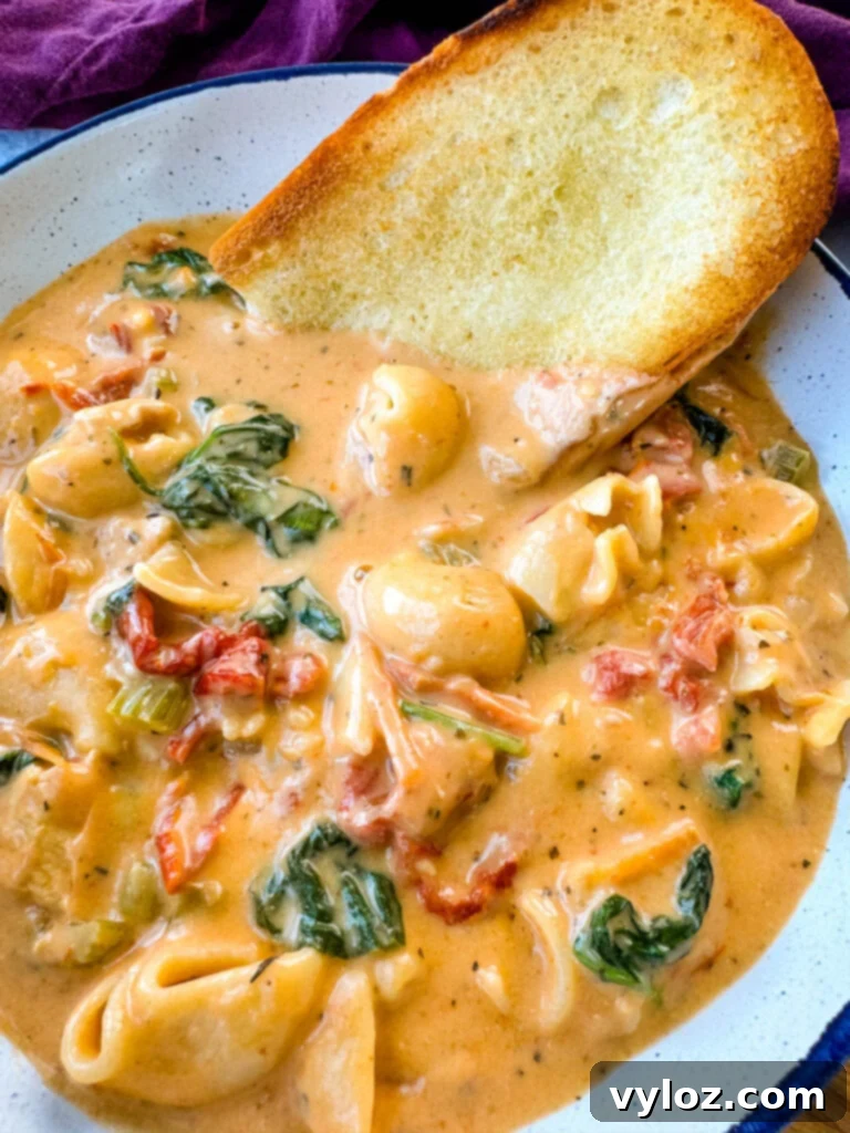 marry me Tuscan chicken soup in a white bowl with a piece of bread