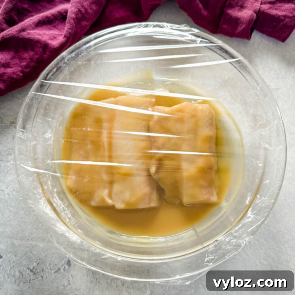 Mastering Nobu's Miso Black Cod 9 black cod marinated with miso sauce in a glass pan