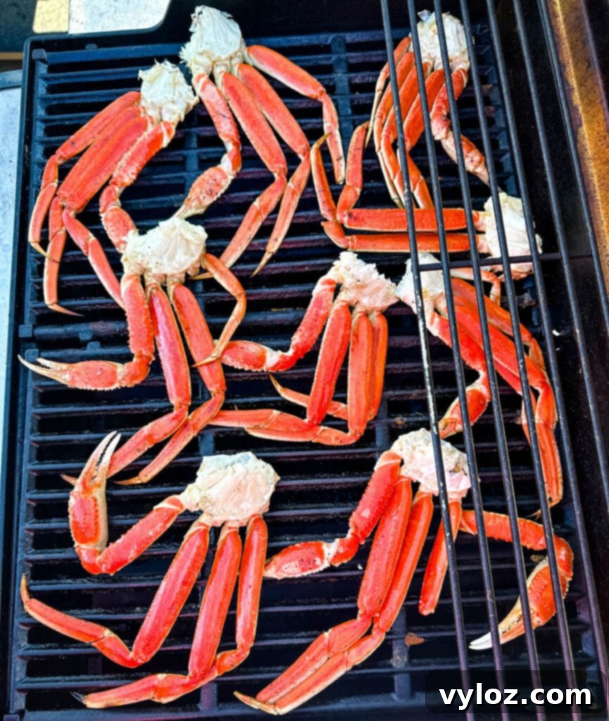 Comparison of snow crab legs and king crab legs on a grill, highlighting their size difference