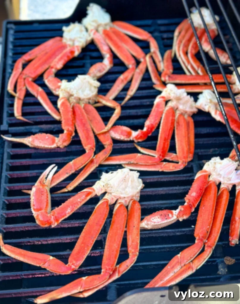 Snow crab legs on a grill, showing a slight char and golden color from the butter