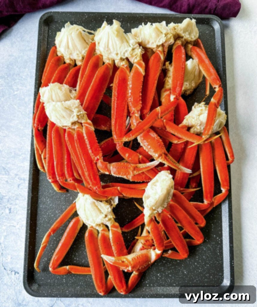 Two clusters of smoked crab legs resting on a metal sheet pan