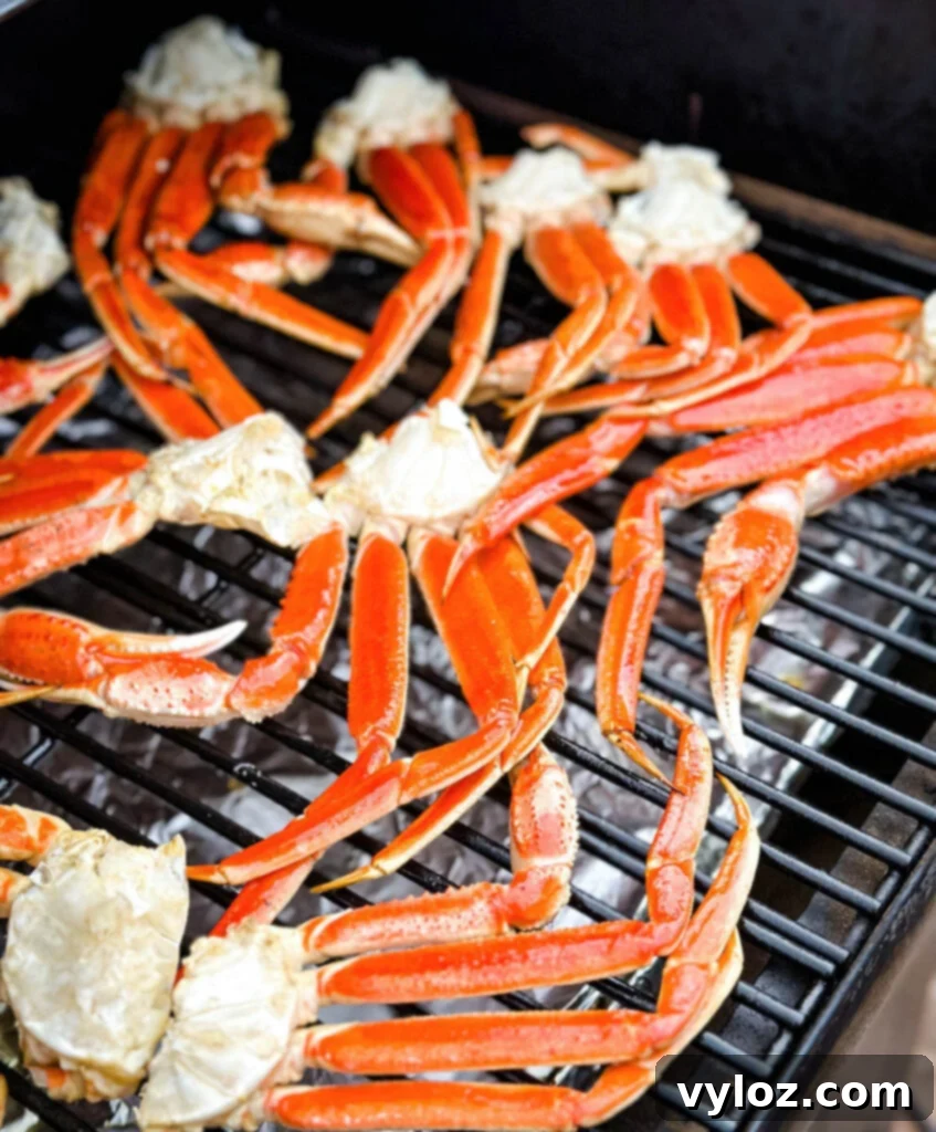 Close-up of smoked crab legs cooking on a Traeger grill, showing the smoky ambiance