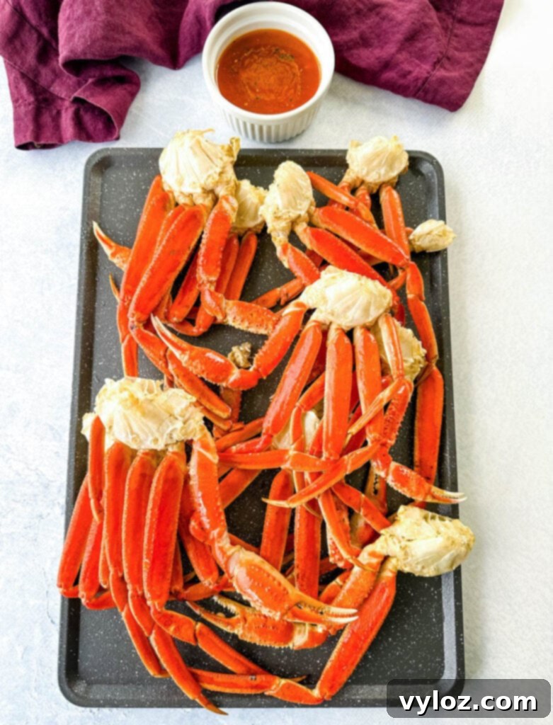 Platter of smoked crab legs served with a side of smoky garlic butter for dipping