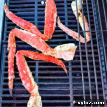 Grilled king crab legs on a grill, showing the final cooked product