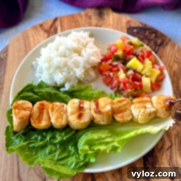 Chargrilled Citrus Scallops 11 grilled scallops on a plate with lettuce, rice, and vegetables