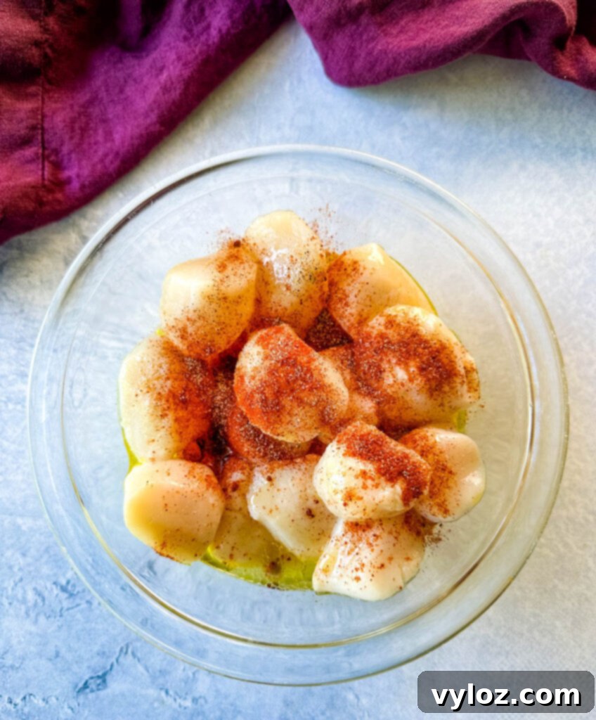 Chargrilled Citrus Scallops 5 raw seasoned scallops in a glass bowl