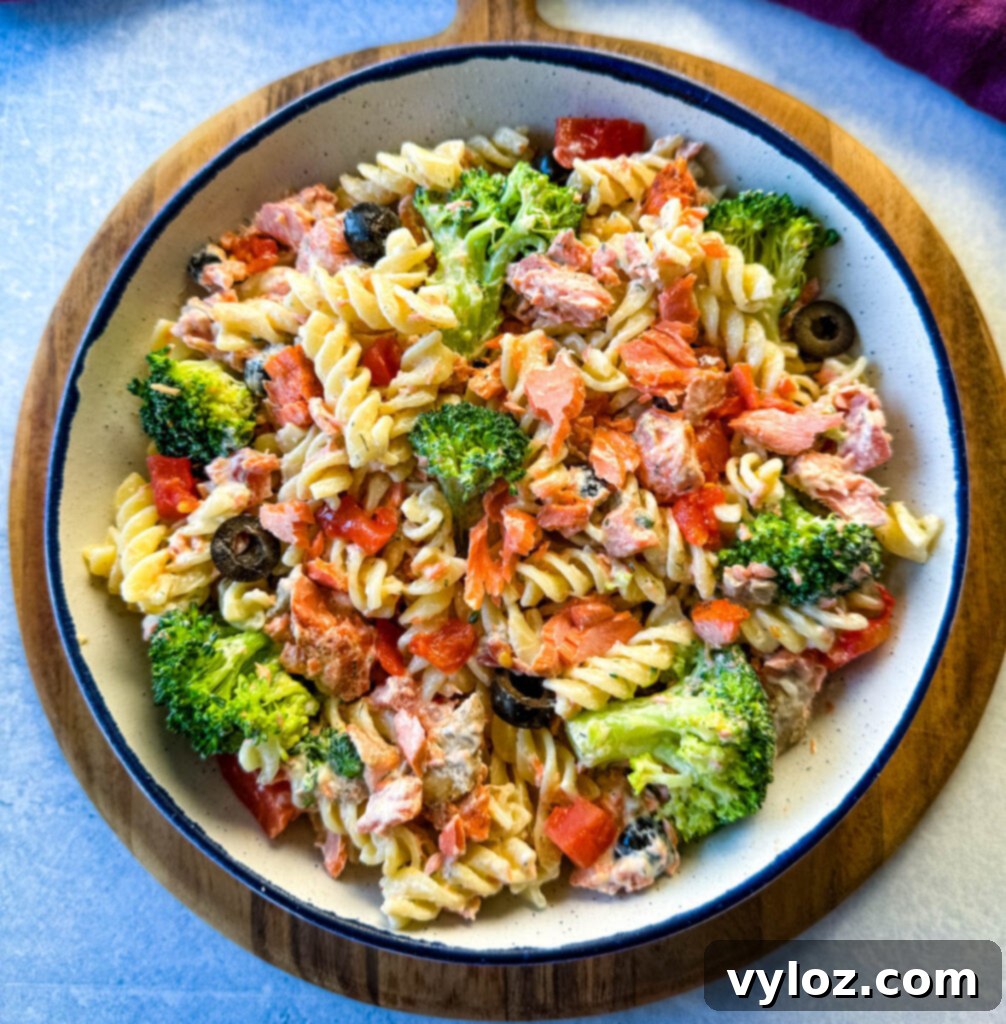 salmon pasta salad with broccoli and tomatoes in a white bowl