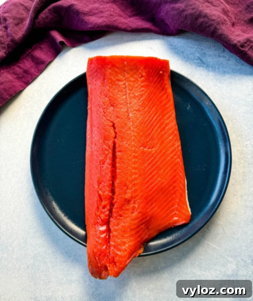 Two raw salmon fillets on a blue ceramic plate, showing vibrant color and smooth texture.