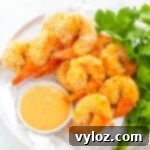 air fryer Bang Bang Panko Breaded Fried Shrimp on a white plate served with a spicy sweet chili sauce