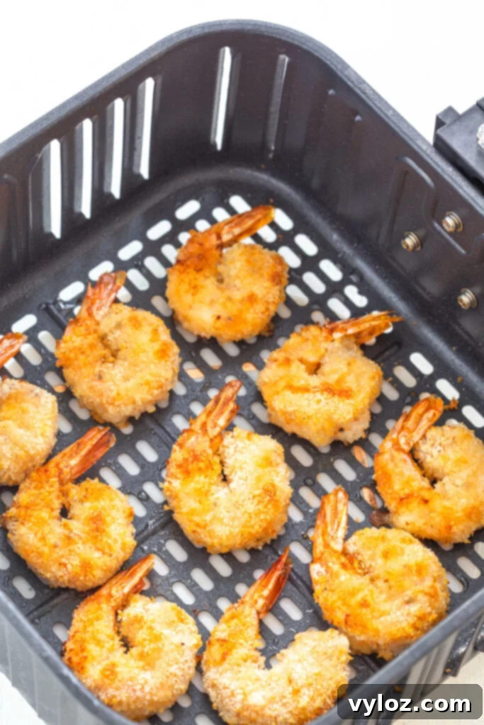 Air fried shrimp cooking in the air fryer basket