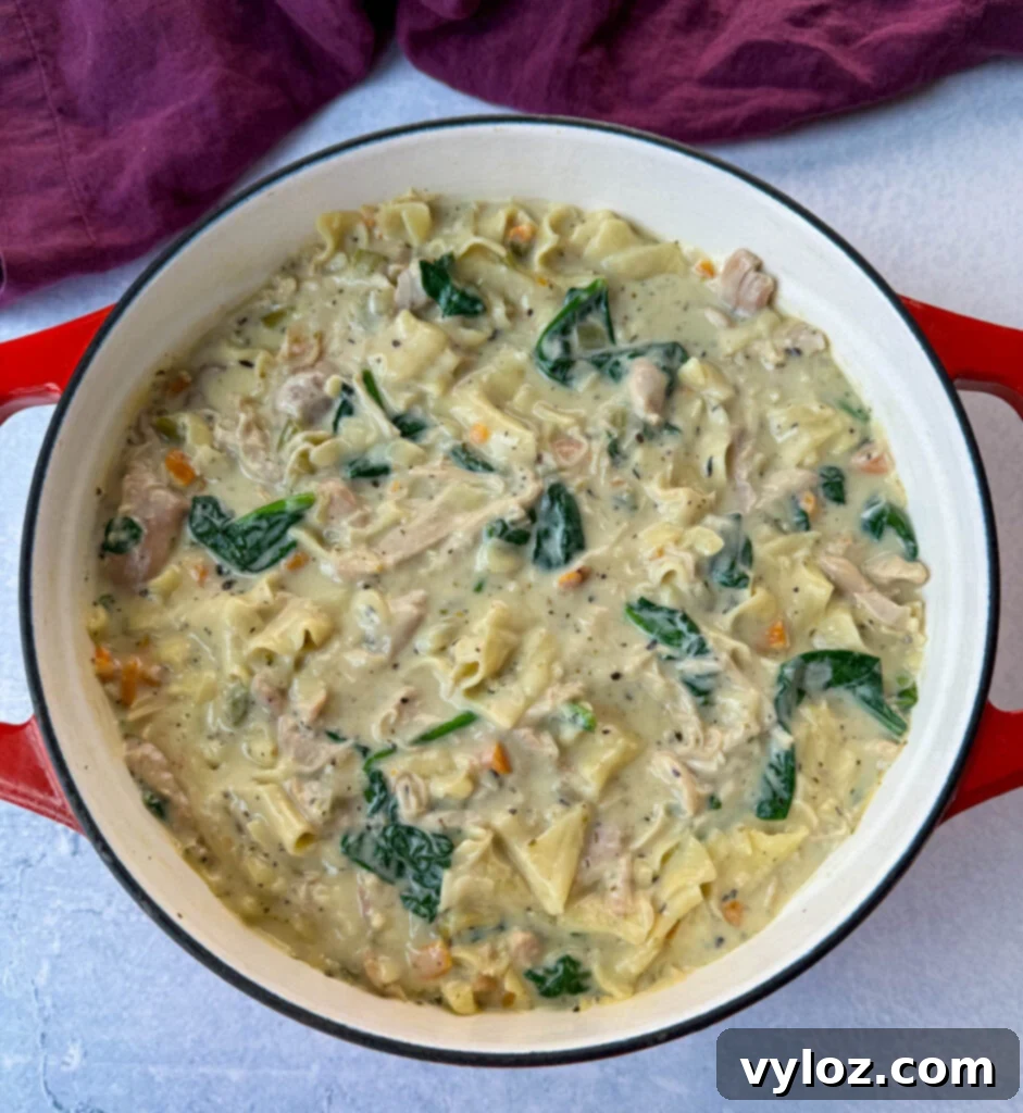 Creamy White Lasagna Soup 14 White lasagna soup in a Dutch oven, rich with carrots, celery, and spinach, illustrating the hearty texture.