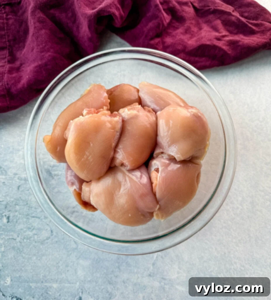 Creamy White Lasagna Soup 6 Raw boneless, skinless chicken thighs in a glass bowl, ready for preparation.
