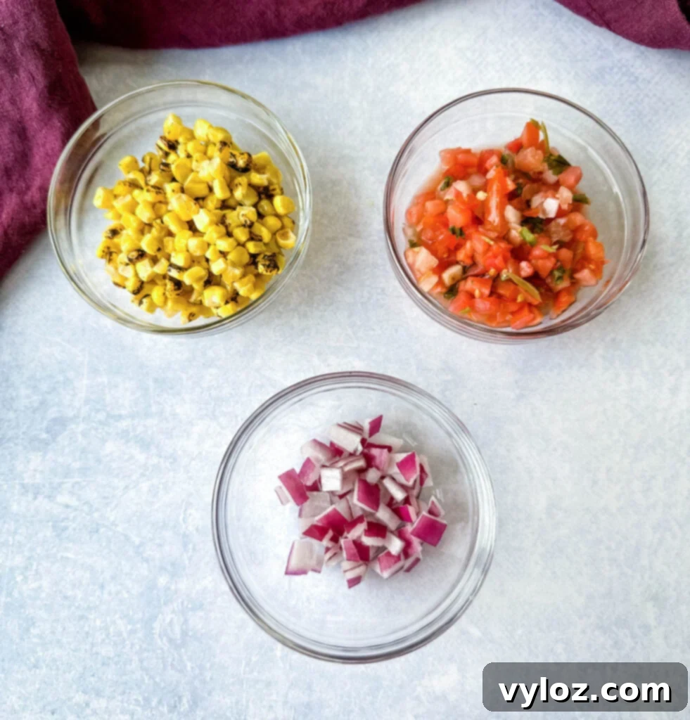 Zesty Shrimp Taco Bowl 4 Individual glass bowls holding roasted corn, vibrant salsa, and finely chopped red onions, ready to be added to the salad.