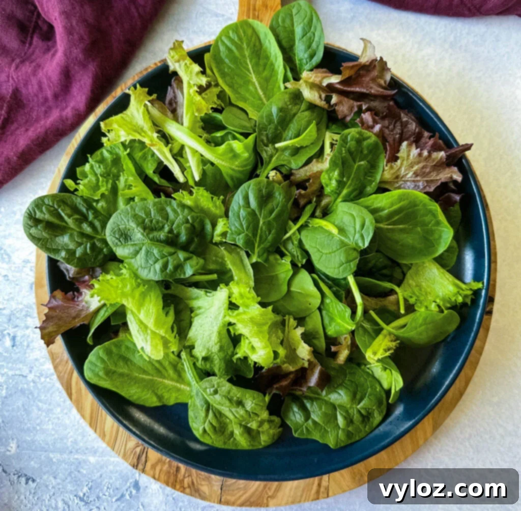 Zesty Shrimp Taco Bowl 8 A vibrant and crisp bed of fresh salad greens artfully arranged on a blue plate, ready for toppings.